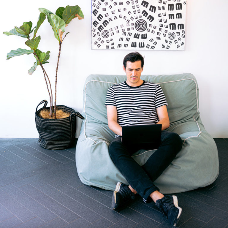 man sitting on beanbag chair while on his laptop, ADHD online testing for adults